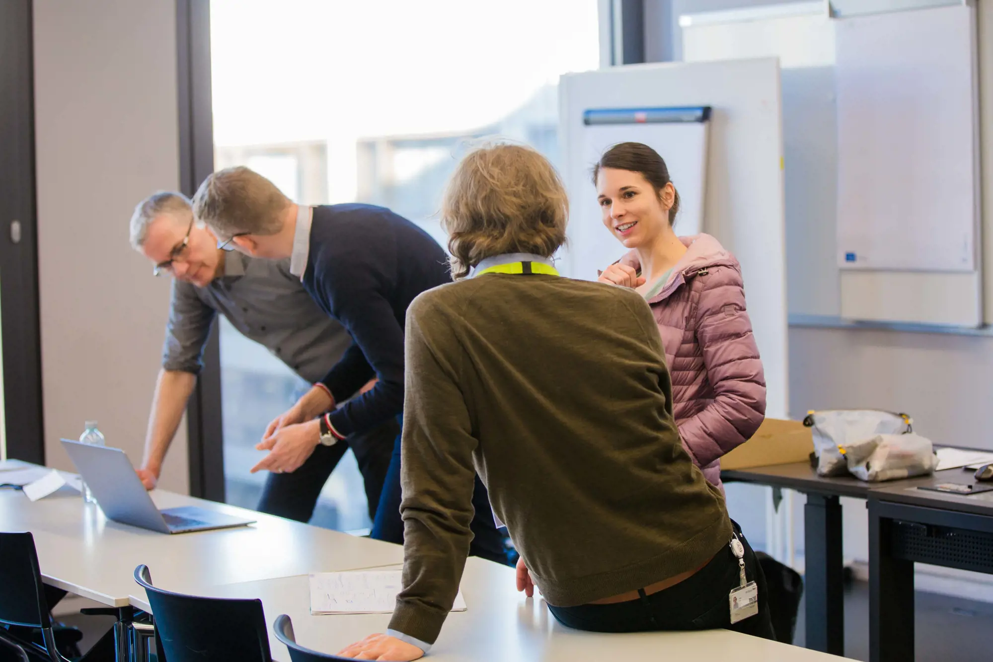 Four researchers discuss in a seminar room.