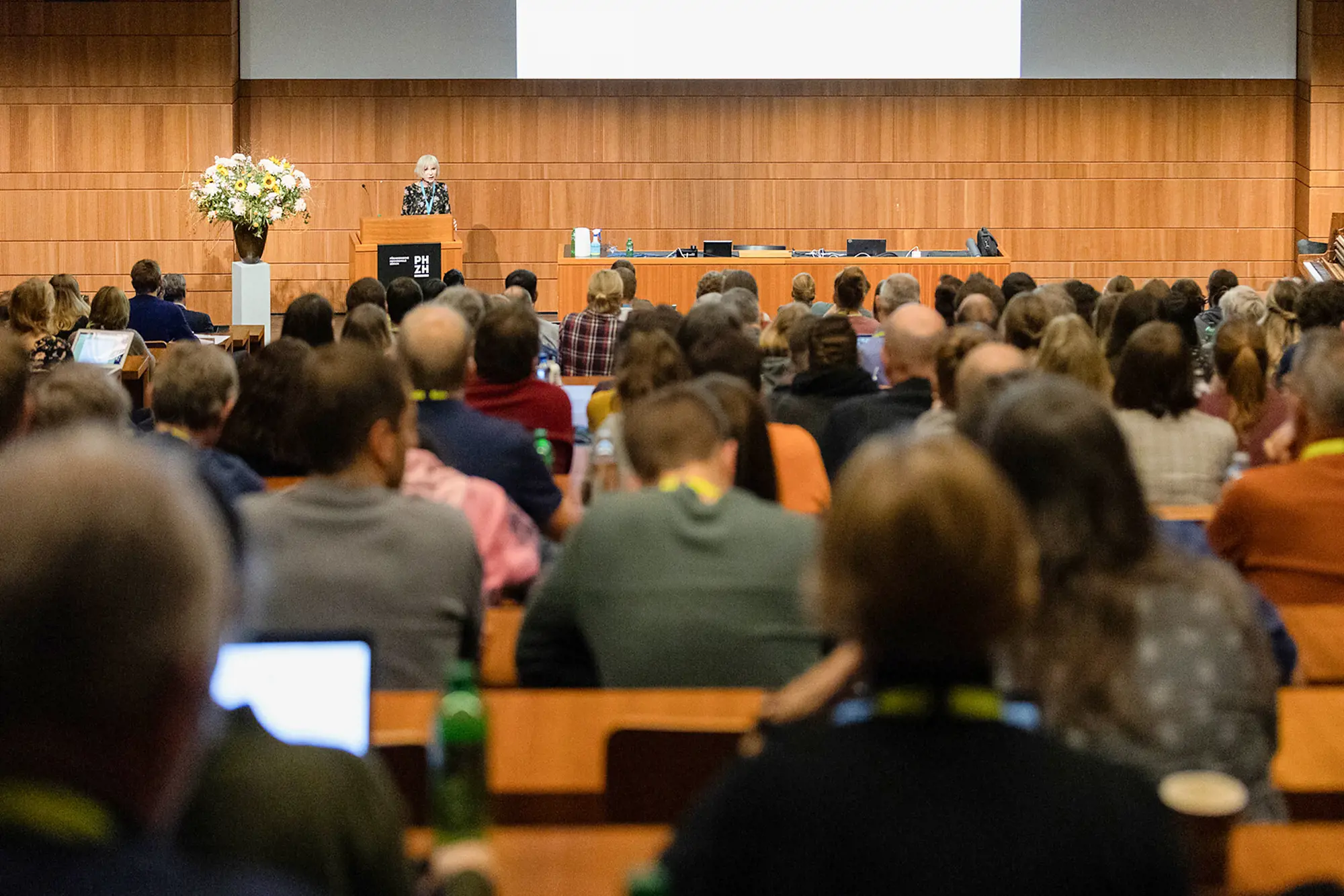 Viele Teilnehmer:innen sitzen im grossen Hörsaal während einer Veranstaltung.