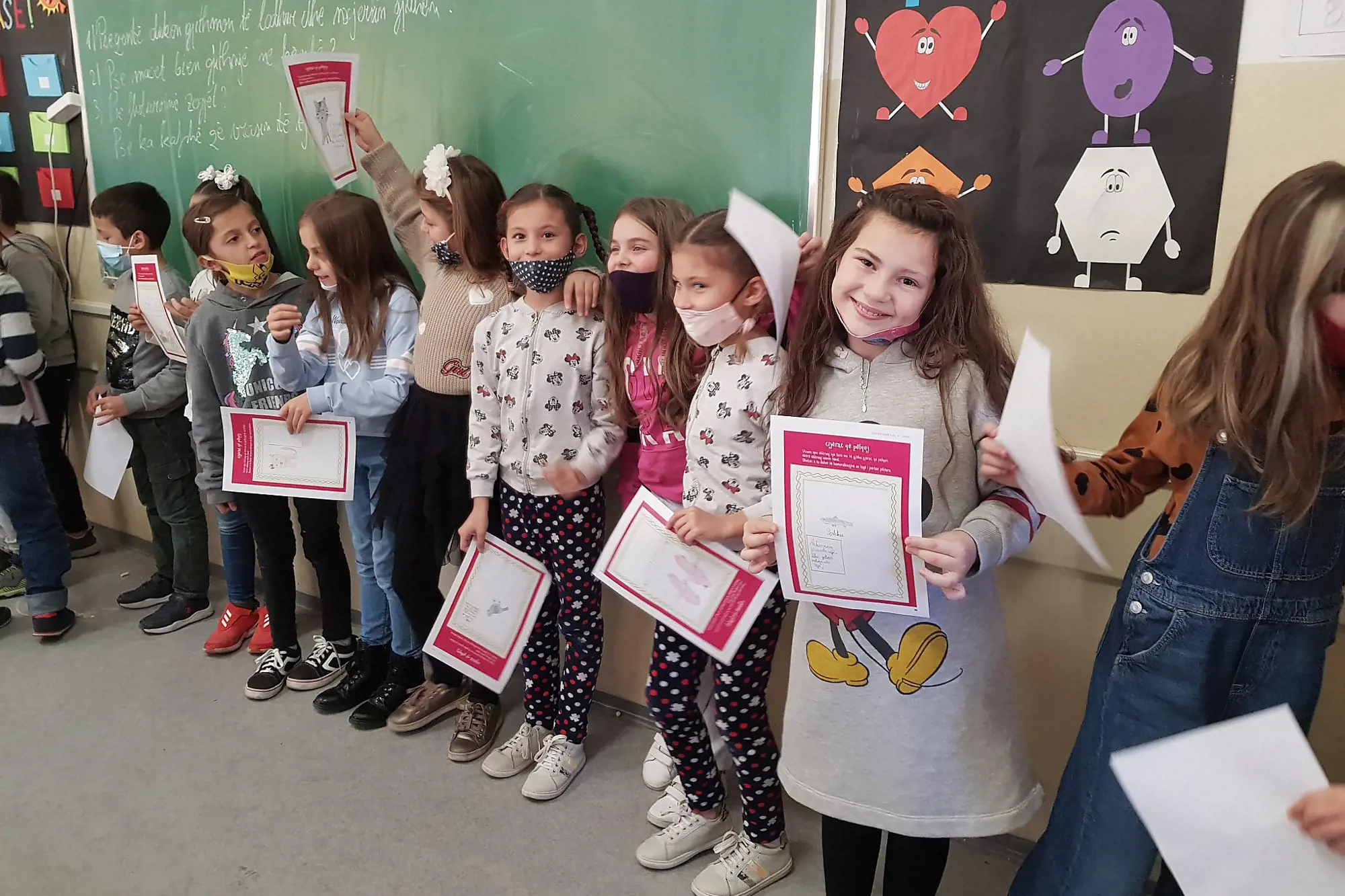 Students in Kosovo show the results from their life skills lesson.