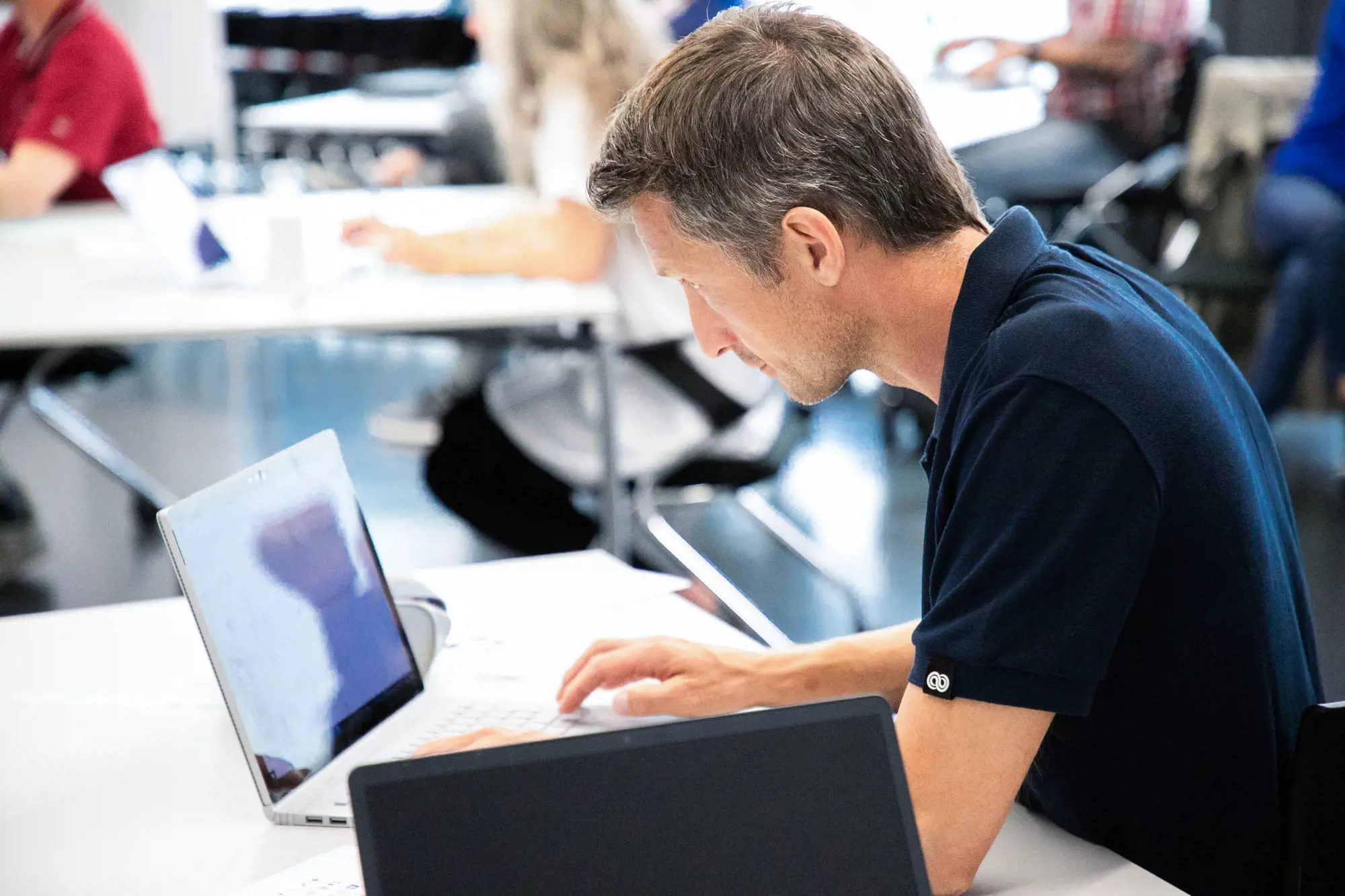 Ein Mann sitzt an einem Laptop.